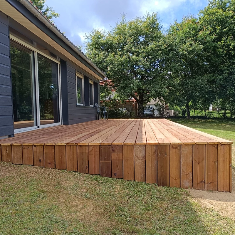 Une terrasse en bois, en pente dans un jardin, installée par SCM