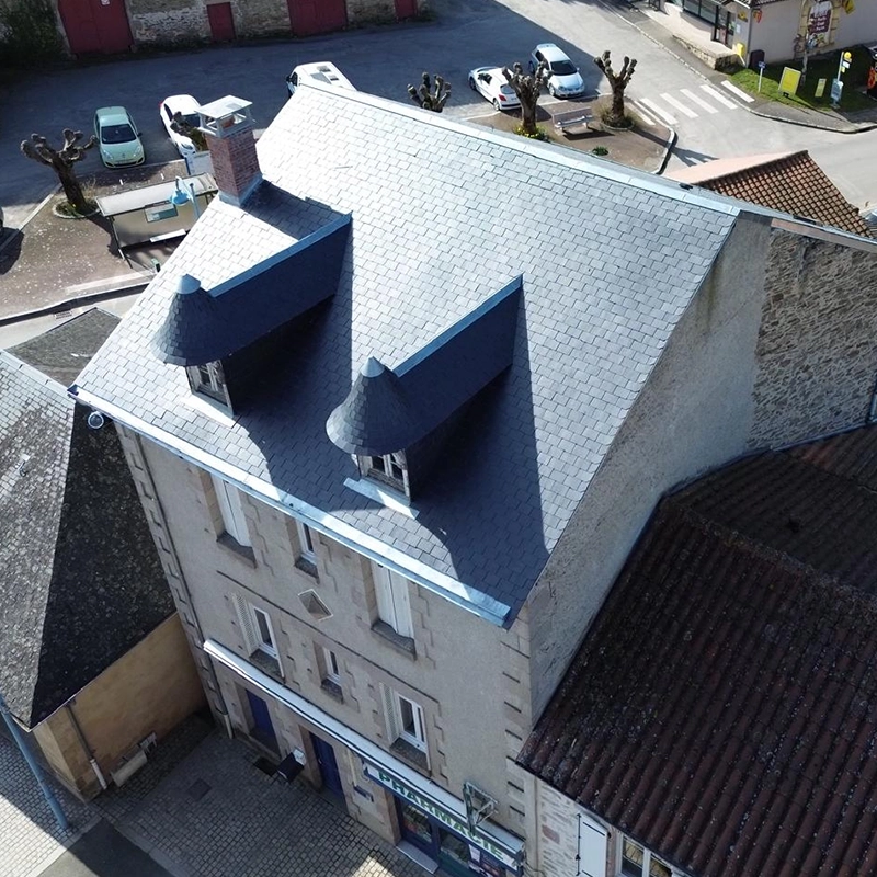 Vue aérienne suite à la rénovation de la toiture en ardoise d'une maison style château.